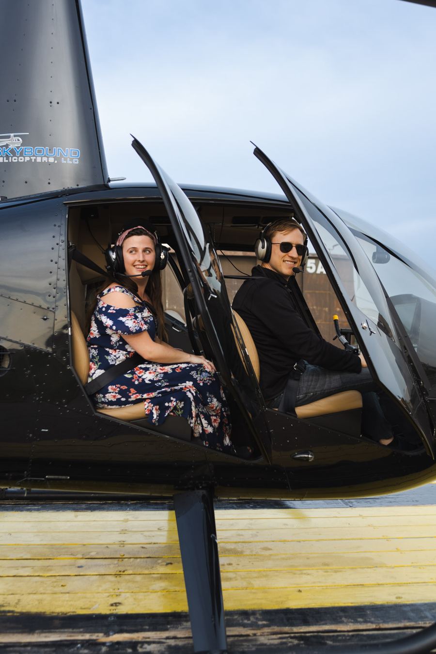 Couple with headsets seated in a helicopter before a date night flight in Kansas City